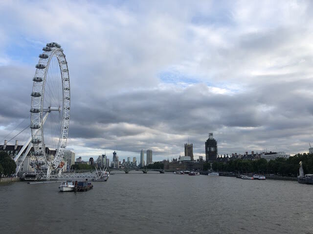 The London Eye and River Thames under a cloudy sky with city buildings visible in the background.
