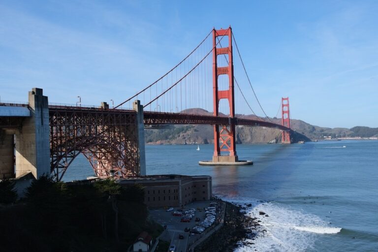 The Golden Gate Bridge in San Francisco spans the water as cars cross and a coastline appears below—a must-see in any first timer’s guide.