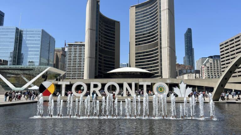 Toronto sign at Nathan Phillips Square, a must-see on any 3 day Toronto itinerary, with fountains and skyline views on a clear day.