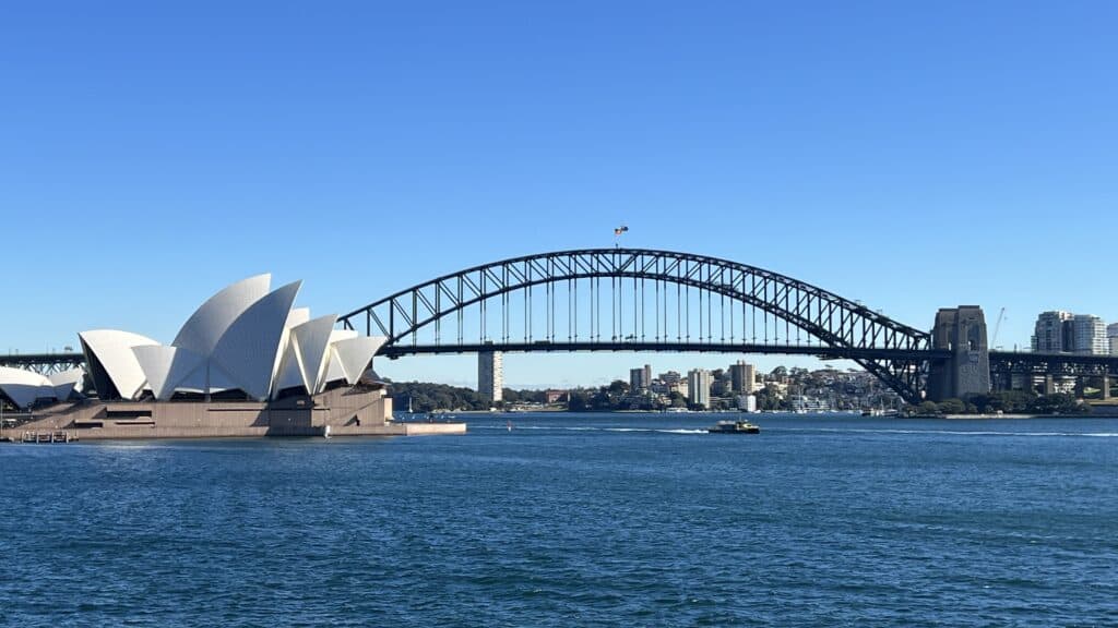 A must-see on any Sydney itinerary: Sydney Opera House and Harbour Bridge shine across the water on a clear, sunny day.