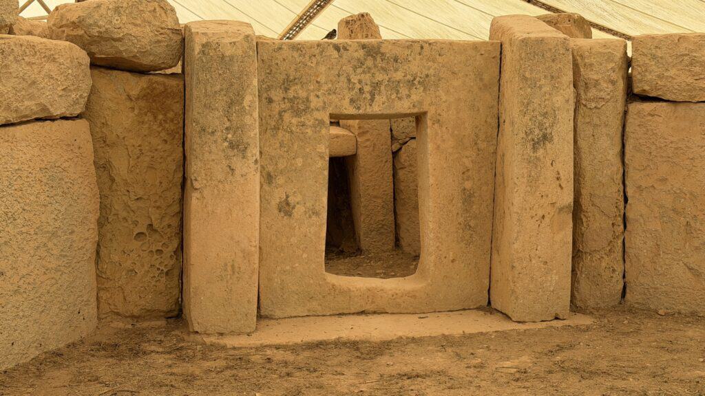 Ancient stone ruins in Malta, ideal for your 3 day Malta itinerary, featuring a large doorway under a protective canopy.